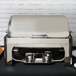 A silver Vollrath New York Chafer cover on a food warmer holding two containers on a table.
