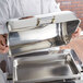 A chef holding a Vollrath New York Chafer cover on a silver tray