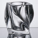 A clear glass candle holder with a swirly design.