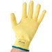 A yellow Cordova cut resistant glove with a blue band.
