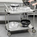 A Metro stainless steel utility cart with bowls on it.