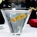 A Libbey stemless martini glass with olives floating in it.