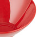A close up of a red slanted melamine bowl.