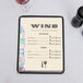 Menu paper with a wine themed bottle design and a glass of wine on the menu.