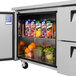 A Turbo Air undercounter refrigerator with drawers open and fruit inside.