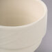 A close-up of a Homer Laughlin ivory china bouillon cup with a handle.