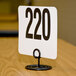 An American Metalcraft black swirl base card holder with white table number 200 on it.