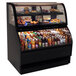 A black Structural Concepts Harmony refrigerated and dry dual service merchandiser case on a bakery counter with food and drinks.