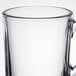 A close up of a Libbey clear glass coffee mug with a handle.