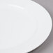 A close up of an Arcoroc white porcelain salad plate with a white rim.