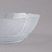 A Carlisle clear polycarbonate bowl with a leaf design on it.