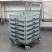 A gray Noble Products dish and glass rack dolly with plastic baskets on it.