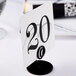 A black and white table number on a Cal-Mil iron card holder.