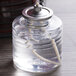 A glass jar with a clear liquid candle fuel inside.