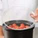 A black container with a clear Cambro lid full of tomatoes.