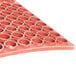 A red heavy-duty rubber Cactus Mat with holes in it.