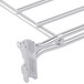 A close-up of a Metro stainless steel wire shelf divider clip.
