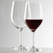 Two Stolzle Bordeaux wine glasses filled with red wine.
