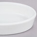 A white Hall China oval baker dish on a gray surface.