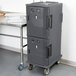 A large black plastic container with a door on a Cambro cart.