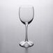 A clear Libbey tall wine glass on a white surface.