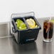 A San Jamar Mini Dome 2-Compartment Condiment Bar on a counter with lemons and limes in it.