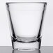 A close-up of a GET clear plastic shot glass on a table.