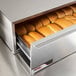 An APW Wyott hot dog bun warmer drawer full of buns.