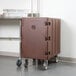 A dark brown plastic Cambro cart for food pans on wheels.