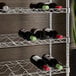 A Regency metal wire rack with wine bottles on it.