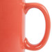 A close up of a Tuxton Cinnebar C-Handle mug in orange.