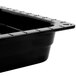 A black GET Melamine food pan with holes displayed on a counter.