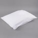 A white JT Eaton bed bug proof pillow protector on a gray surface.