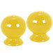 A pair of yellow salt and pepper shakers with holes.