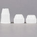 A group of white plastic caps on a white surface.