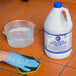 A gloved hand cleaning a tile floor with Pure Bright bleach