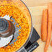 Food in a Waring food processor next to carrots.