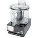 A black Waring food processor with a clear lid on a counter.