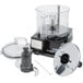 A Waring food processor with a clear bowl and lid on a counter.