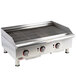 An APW Wyott stainless steel charbroiler on a counter with three burners and knobs.