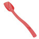 A red plastic spoon with a long handle and holes in the bowl.