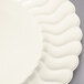 A close-up of a Fineline Flairware ivory plastic plate with a wavy design.