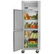 A Traulsen reach-in refrigerator with left hinged doors full of groceries.