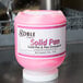 A pink plastic container of Noble Chemical Concentrated Solid Pan Detergent on a counter.