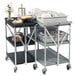 A Carlisle black and silver folding utility cart with food and dishes on it.
