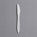 A white plastic knife on a gray background.