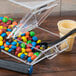 A Cal-Mil stackable topping dispenser with a black holster and clear plastic containers.