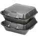 A stack of Genpak black 3-compartment foam containers with lids.