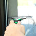 A person using a Unger ErgoTec window squeegee to clean a window.