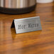 A silver Cal-Mil hot water beverage tent sign on a hotel buffet counter.